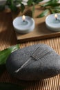 Stone with acupuncture needles on bamboo mat Royalty Free Stock Photo