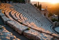 Ancient stone amphitheater with curved seating illuminated by sunset light Royalty Free Stock Photo