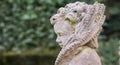 Stone angel statue in garden. Guardian angel statue in sunlight as a symbol of love in garden. Royalty Free Stock Photo