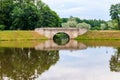 Stone arch bridge across lake in Gatchina  Russia Royalty Free Stock Photo