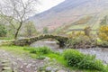 Stone arch bridge across a small stream in Lake District National Park Royalty Free Stock Photo