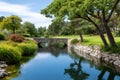 Stone arch bridge reflecting in park river with golf course Royalty Free Stock Photo