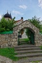 Stone arch entrance with steps to the orthodox church. Roofs and domes with crosses against the blue sky. Russia, summertime