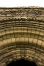 Stone arch on an entrance to a medieval abbey ruin.