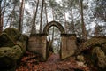 Stone arch fairytale portal with autumn leaves, Vranov castle gothic ruins with pantheon on steep sandstone rock cliff near