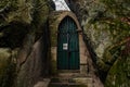 Stone arch fairytale portal with autumn leaves, Vranov castle gothic ruins with pantheon on steep sandstone rock cliff near