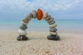 Stone arch with red pebble at the top at the beach