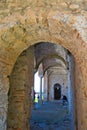 Stone-arched walkway in an ancient building with a group of tourists in Mystras, Greece Royalty Free Stock Photo