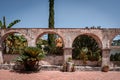 stone arches along paved sidewalk with palm trees on a sunny summer day Royalty Free Stock Photo