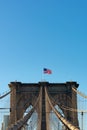 Arches on the Brooklyn Bridge with an American Flag in New York City and a Blue Sky Royalty Free Stock Photo