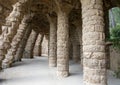 Stone architectural elements creating a walkway under a walkway in Park Guell in Barcelona, Spain.