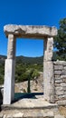 A stone archway in the middle of a stone wall with a blue sky in the background Royalty Free Stock Photo