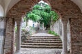 Udine - Stone archway with two stone pillar, leading to a narrow pathway lined with stone steps