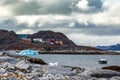 Stone arctic coast, motorboat and blue iceberg floating in the b Royalty Free Stock Photo