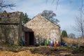 A stone barn on a rural farm with colourful wheelbarrows against the wall