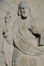 Stone bas-relief of the face of Christ holding up two fingers. Royalty Free Stock Photo