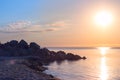 Stone beach on the sea shore. blue sky horizon. reflection of the sunrise