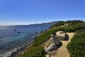 Stone bench with amazing view of pure clear azure coast near the Spiaggia di Mari Pintau beach in Sardinia, Sardinia, Italy