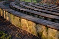 Stone bench in the arch lined with wooden planks. outdoor theater amphitheater. summer cinema auditorium. granite paving and reces