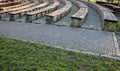 Stone bench in the arch lined with wooden planks. outdoor theater amphitheater. summer cinema auditorium. granite paving and reces