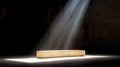 A stone bench in a dark room with light shining from above. Royalty Free Stock Photo