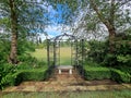 stone bench seat under a garden archway overlooking a duck pond Royalty Free Stock Photo