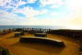 Stone benches at the beach with blue ocean water and gorgeous clouds Royalty Free Stock Photo