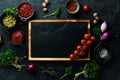 Stone black cooking background. Kitchen board with vegetables and spices. On a black stone background. Royalty Free Stock Photo