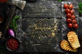 Stone black cooking background. Kitchen board with vegetables and spices. On a black stone background. Royalty Free Stock Photo