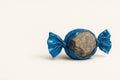 A stone in a blue wrapper is like a candy. Space for text. Royalty Free Stock Photo