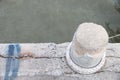 Stone bollard with rope on boat dock and sea Royalty Free Stock Photo