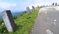 Stone bollards on tourist path to Vrbatova Bouda in Krkonose Giant Mountains. Blurred walking tourists visible in the distance.