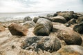 Stone boulders on the beach at low tide.Wadden Sea Coast.Stone groyne on cloudy sky background.Marine photo wallpaper Royalty Free Stock Photo