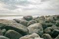 Stone boulders on the beach at low tide.Wadden Sea Coast.Stone groyne on cloudy sky background.. Marine photo wallpaper Royalty Free Stock Photo