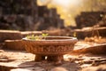 a stone bowl sitting on the ground in front of a stone wall