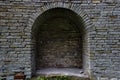 Stone brick antique arch is a window. Northern Europe, the castle. Fortress wall made of gray bricks. Royalty Free Stock Photo