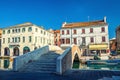 Stone brick bridge Ponte Pescheria across Vena water canal and old buildings in historical centre of Chioggia