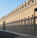 Stone bricks old decorated fence with wooden door and shadows of decorations of the opposite fence, Mosque of Ibn Tulun Royalty Free Stock Photo