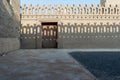 Stone bricks old decorated fence with wooden door and shadows of decorations of the opposite fence, Mosque of Ibn Tulun Royalty Free Stock Photo