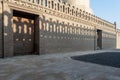 Stone bricks old decorated fence with wooden door and shadows of decorations of the opposite fence, Mosque of Ibn Tulun Royalty Free Stock Photo