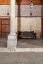 Stone bricks wall and aged wooden couch at main hall of historic Mamluk era Beshtak Palace, Cairo