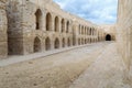 Stone bricks wall with embedded recessed arches at an old abandoned horse stall at the Citadel of Qaitbay, Alexandria, Egypt Royalty Free Stock Photo