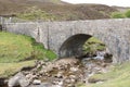 A stone bridge crossing a small river Royalty Free Stock Photo