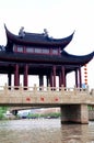 A stone bridge with high red pillars and lanterns hanging under the eaves has a small two-story attic, known as a covered bridge,