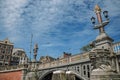 Stone bridge over canal decorated by sculpture of ship`s bow and elegant light post in Amsterdam. Royalty Free Stock Photo