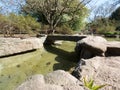 Stone bridge over a creek in the Asian garden with stones in the front