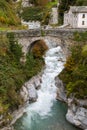 Stone bridge over the river Mera in the old Swiss village Promontogno