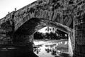 Stone bridge and reflections in a park puddle Royalty Free Stock Photo