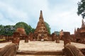 Stone Buddha sitting in front of a pagoda, with ruin of stone pillars