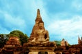 Stone Buddha sitting in front of a pagoda